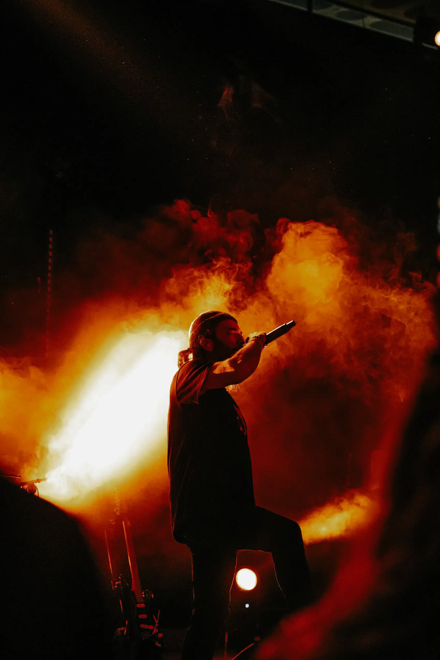Rapper pointing to the crowd through orange smoke