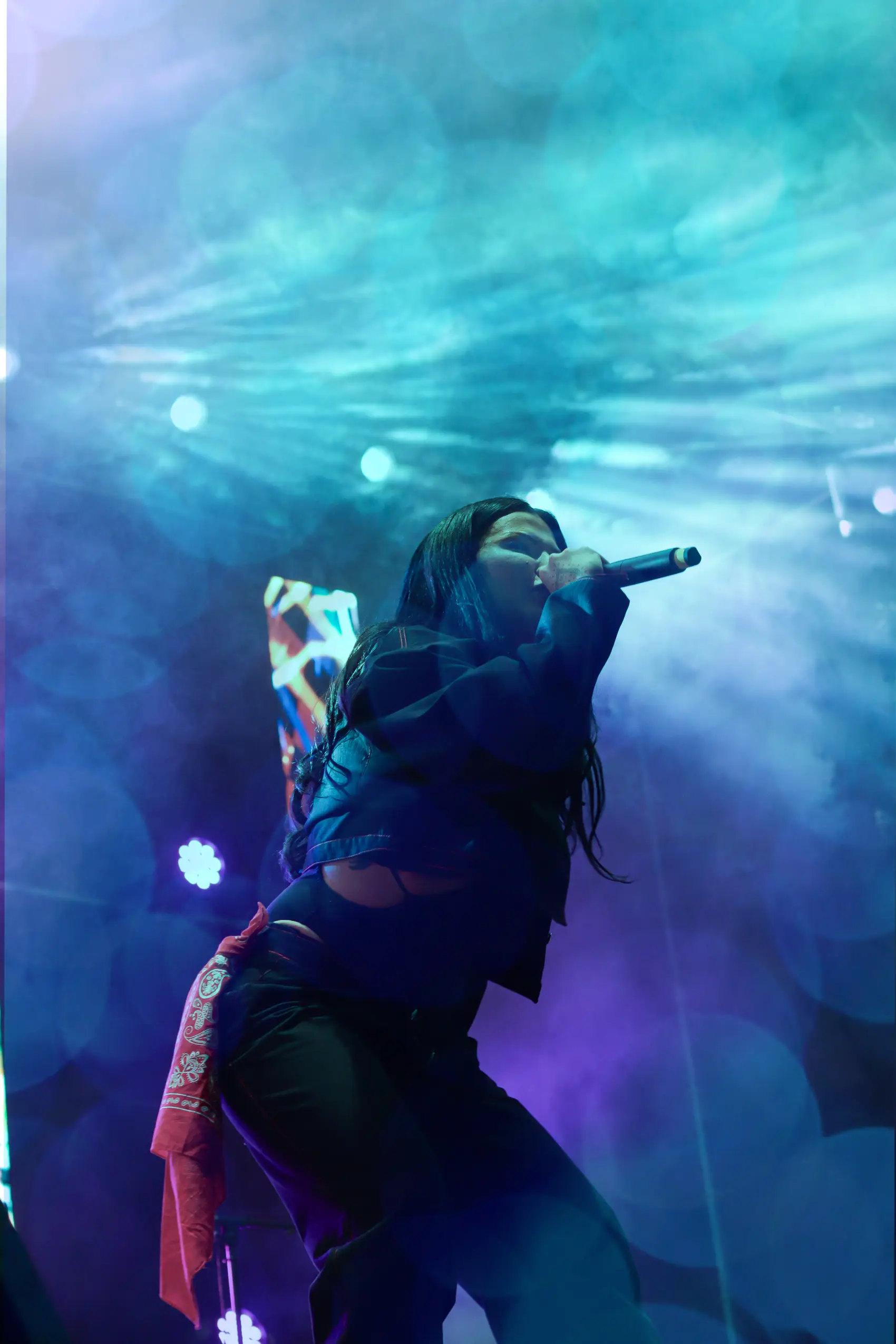 Artist bathed in deep blue light, seen from behind