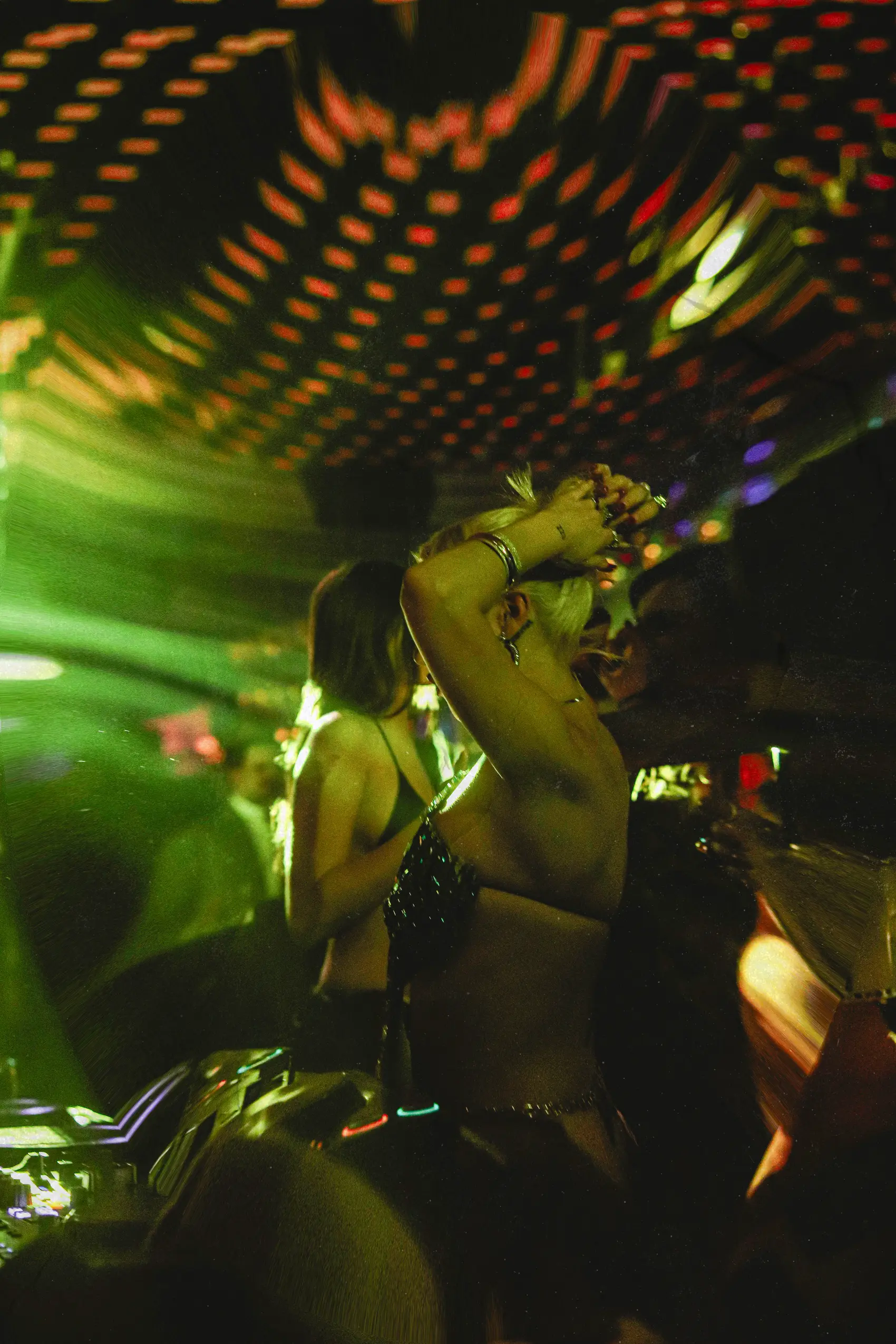 Frontwoman singing under green and pink stage light