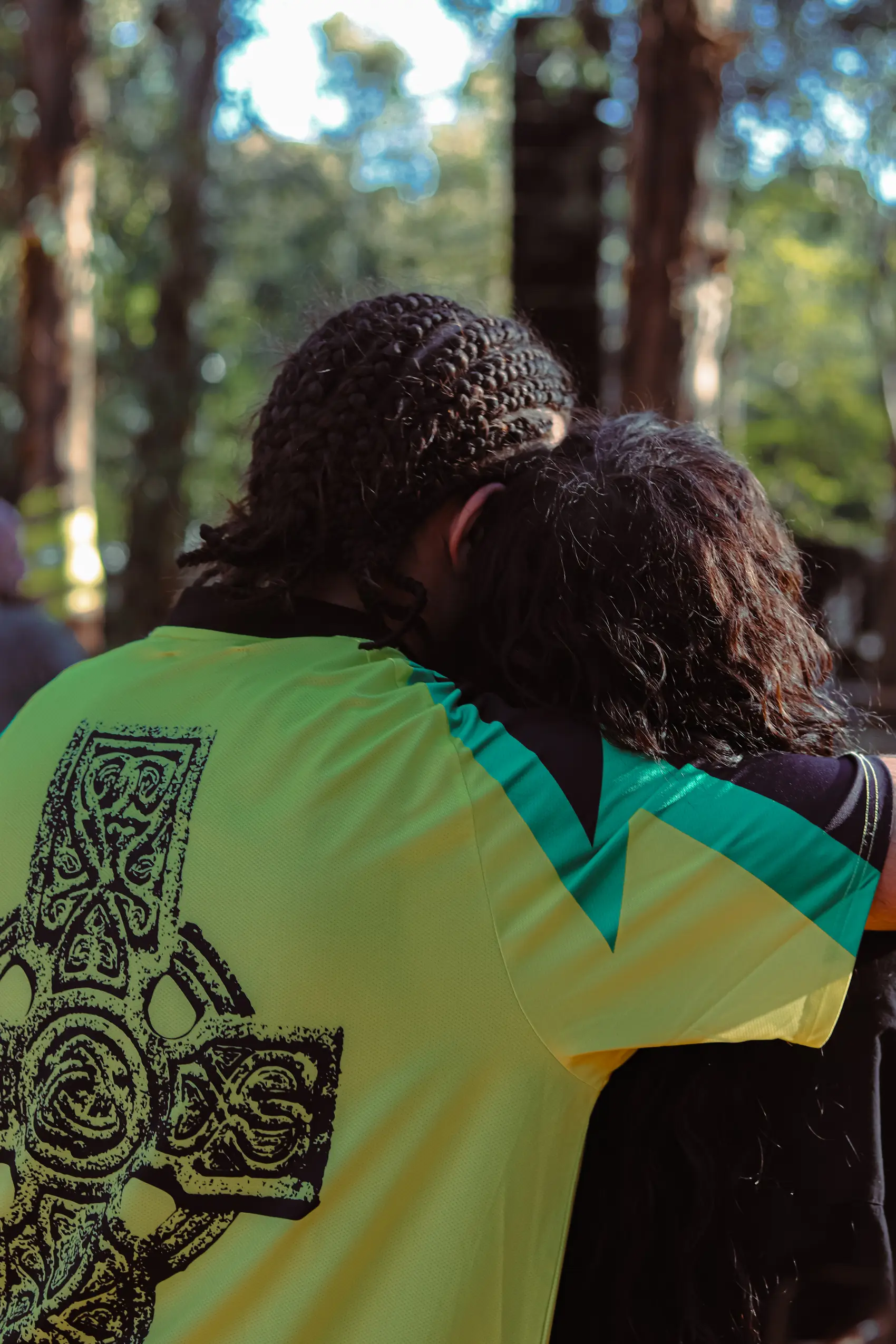 Two friends embracing among festival-goers