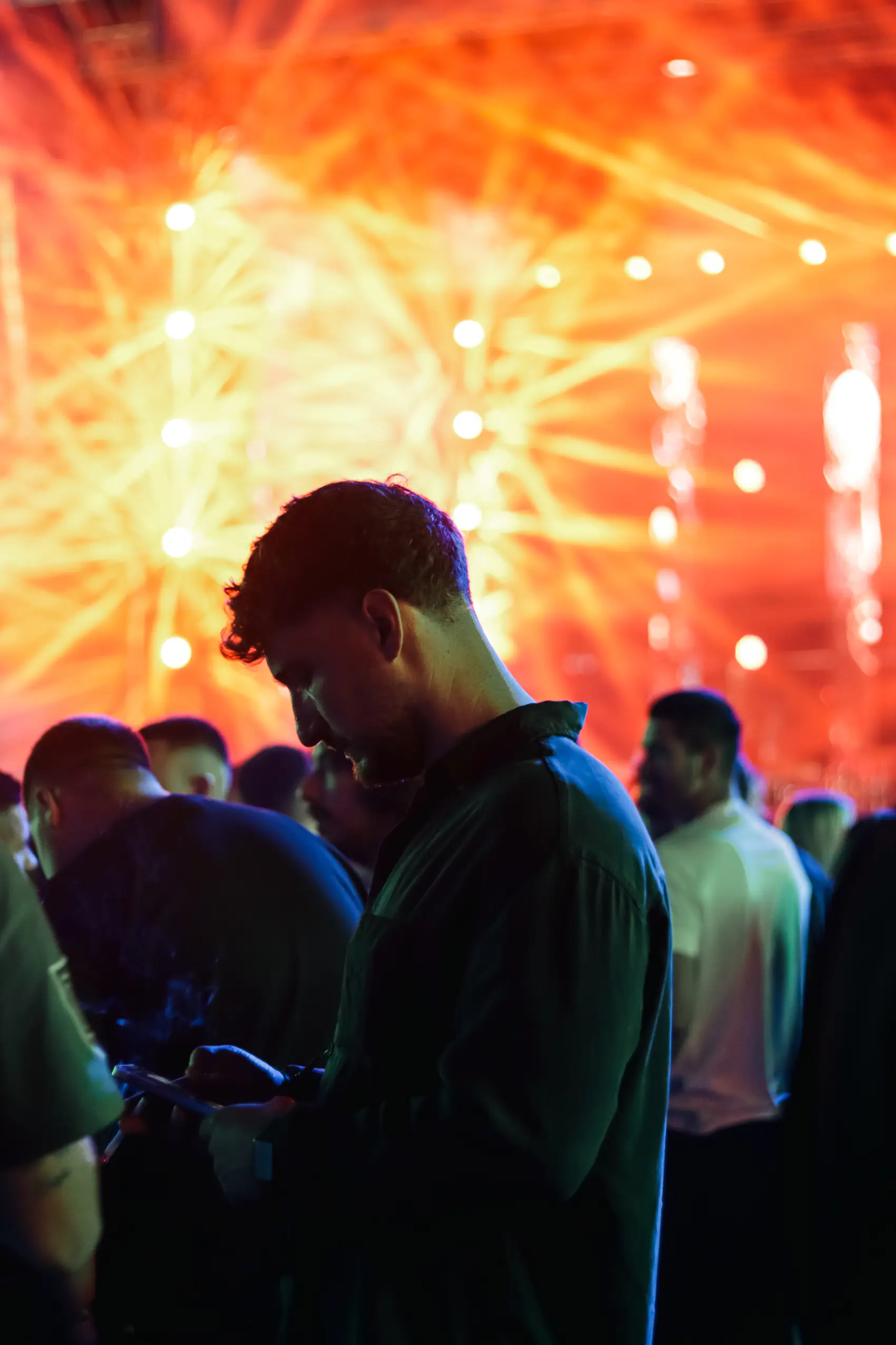 Crowd watching the stage as sparks fall, faces lit with awe