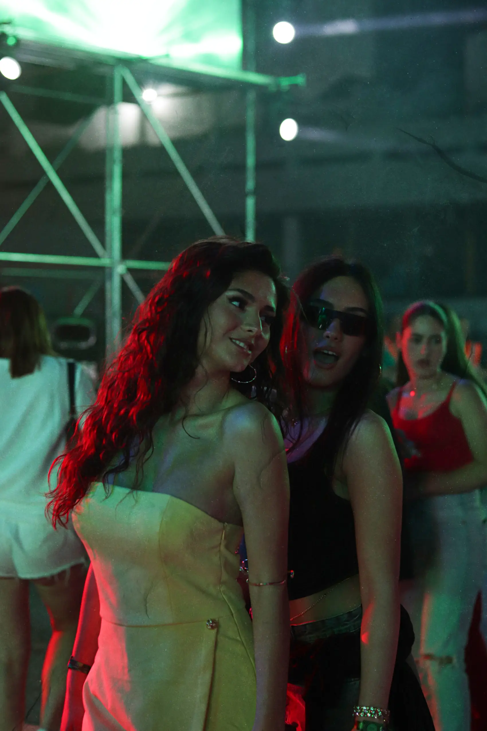 Two friends smiling together in red festival light