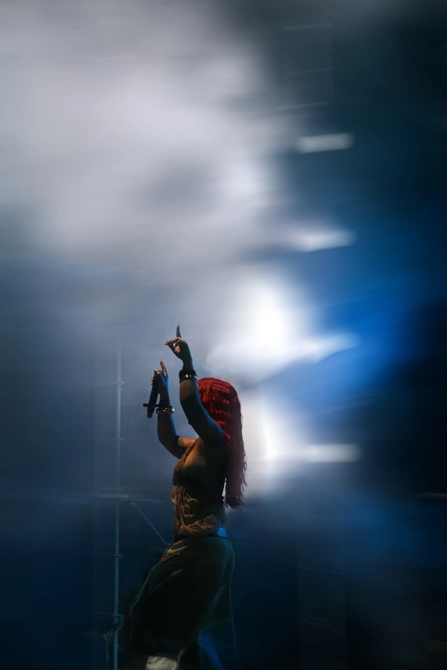 Performer lit by a single blue spotlight on a darkened stage