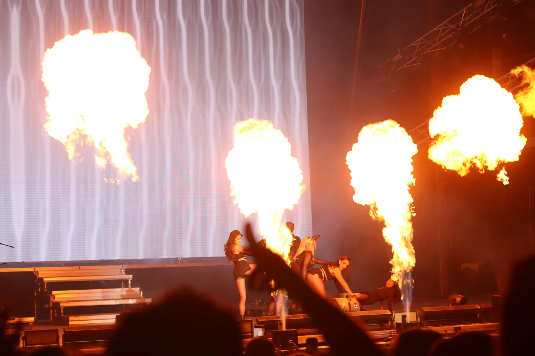 Jets of stage fire rising behind a performer